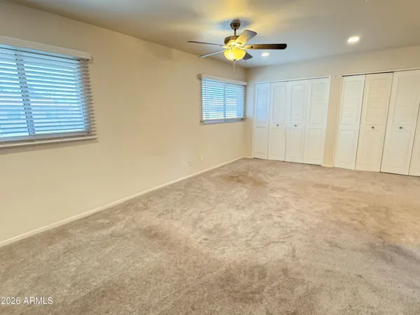 an empty room with a window and a ceiling fan