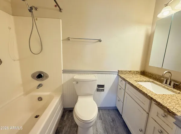 a bathroom with a granite countertop sink a toilet and a bathtub