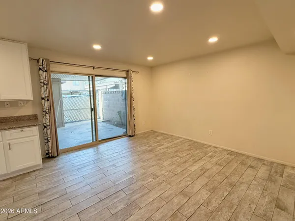 an empty room with wooden floor and natural light