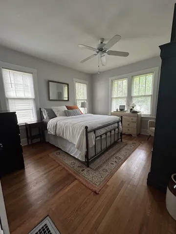 a bedroom with a bed and wooden floor