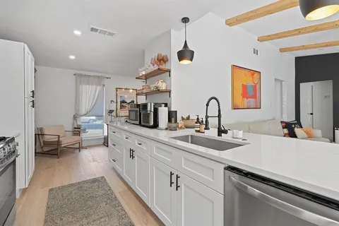 a kitchen with sink and view of living room
