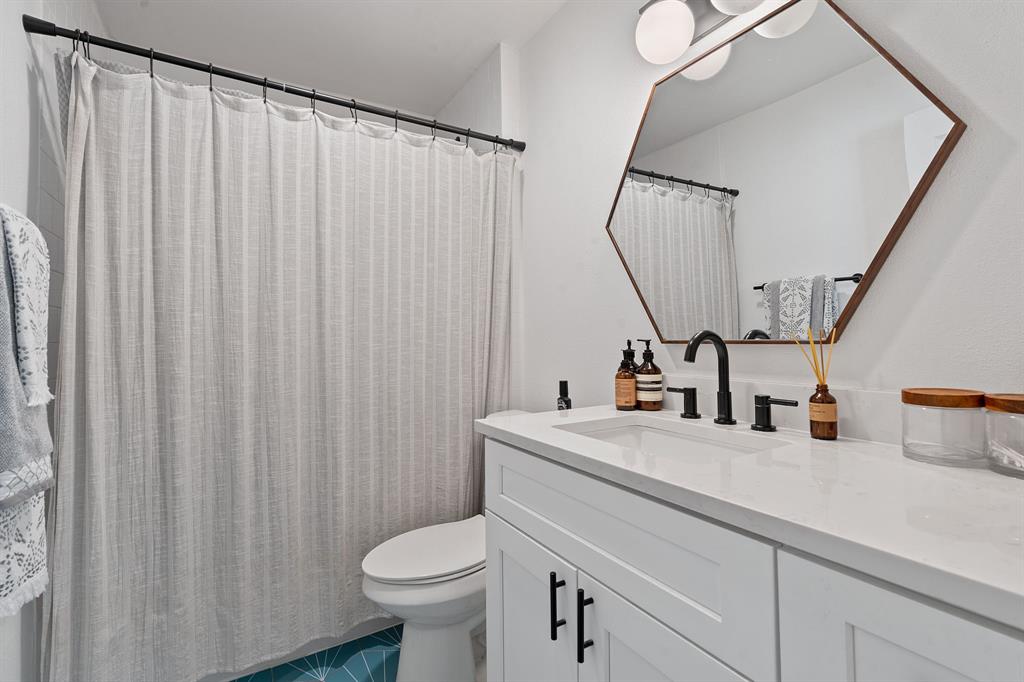 4902 Carsonhill Drive Austin, TX 78723 - Photo 16 of 19 Full bathroom featuring a shower with shower curtain, vanity, and dark tile patterned flooring