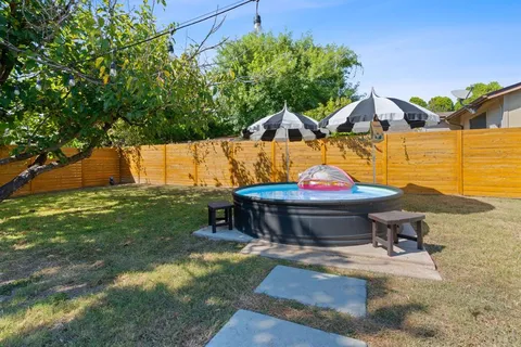 a backyard of a house with table and chairs