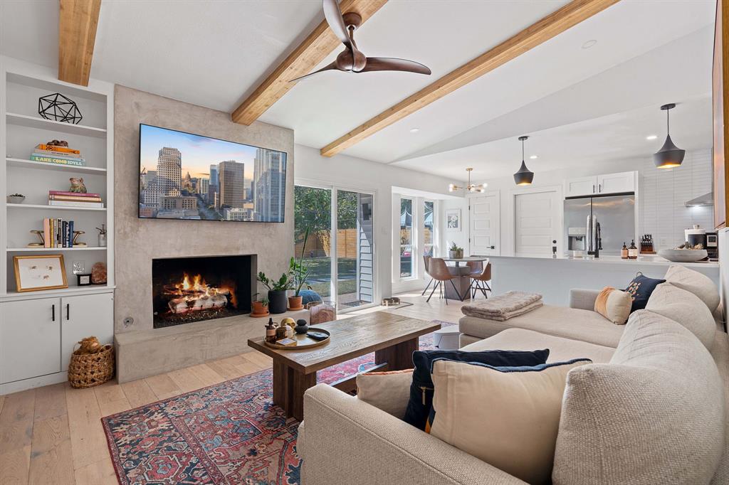 4902 Carsonhill Drive Austin, TX 78723 - Photo 3 of 19 Living area with a fireplace, light wood-style flooring, ceiling fan, a chandelier, and built in features