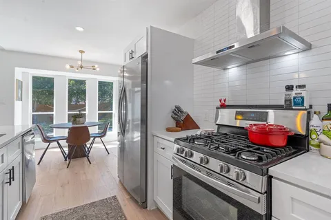a kitchen with a stove and wooden floor