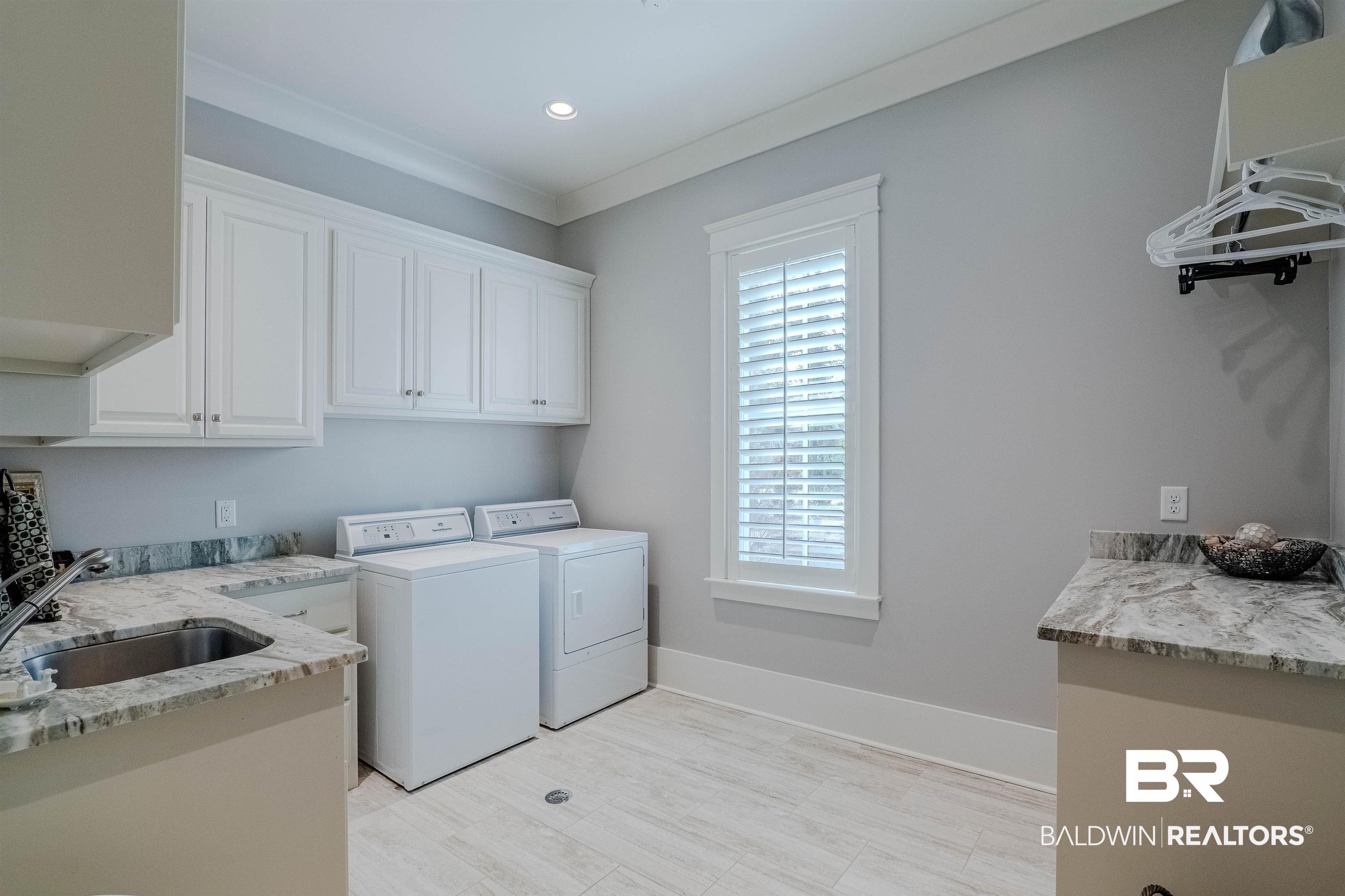 708 Manning Place Fairhope, AL 36532 - Photo 40 of 58 Laundry area featuring cabinets, crown molding, sink, and independent washer and dryer