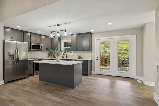 a kitchen with a sink a counter space and wooden floor