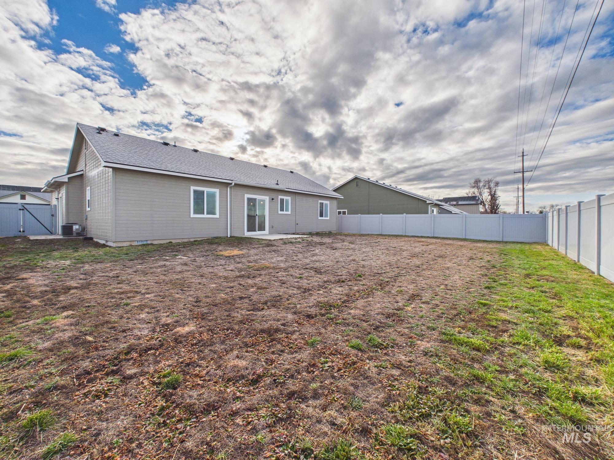 1545 Trail Way Weiser, ID 83672 - Photo 2 of 50 Rear view of property with a fenced backyard, a patio, a gate, and a shingled roof