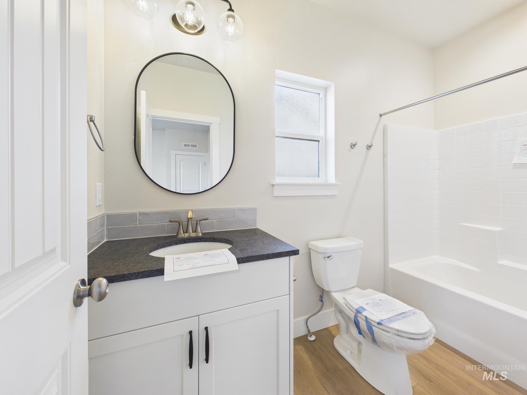1545 Trail Way Weiser, ID 83672 - Photo 21 of 50 Bathroom featuring vanity, light wood finished floors, and shower combination