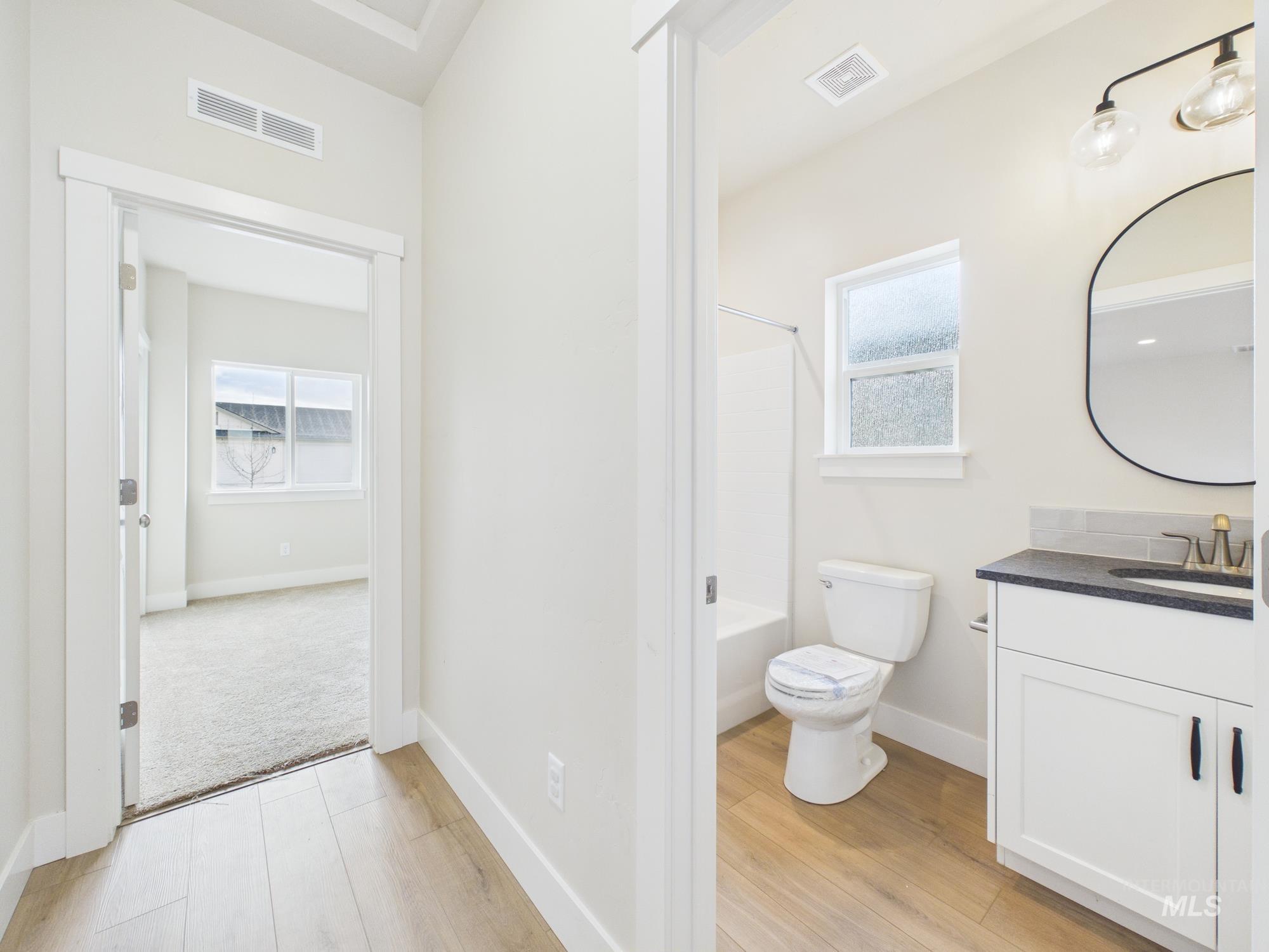 1545 Trail Way Weiser, ID 83672 - Photo 26 of 50 Bathroom featuring vanity, light wood finished floors, and washtub / shower combination