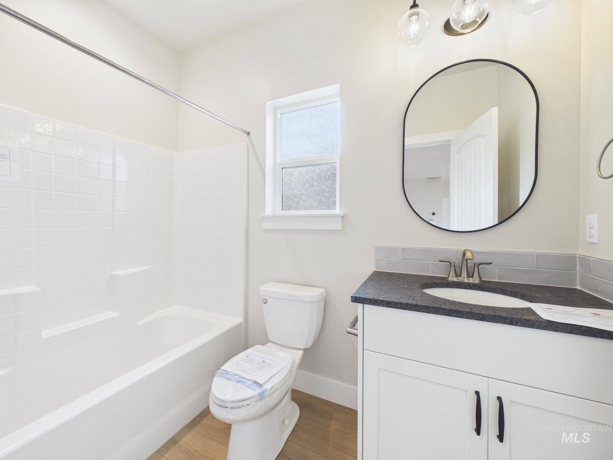 1545 Trail Way Weiser, ID 83672 - Photo 27 of 50 Full bathroom with vanity, wood finished floors, and tub / shower combination