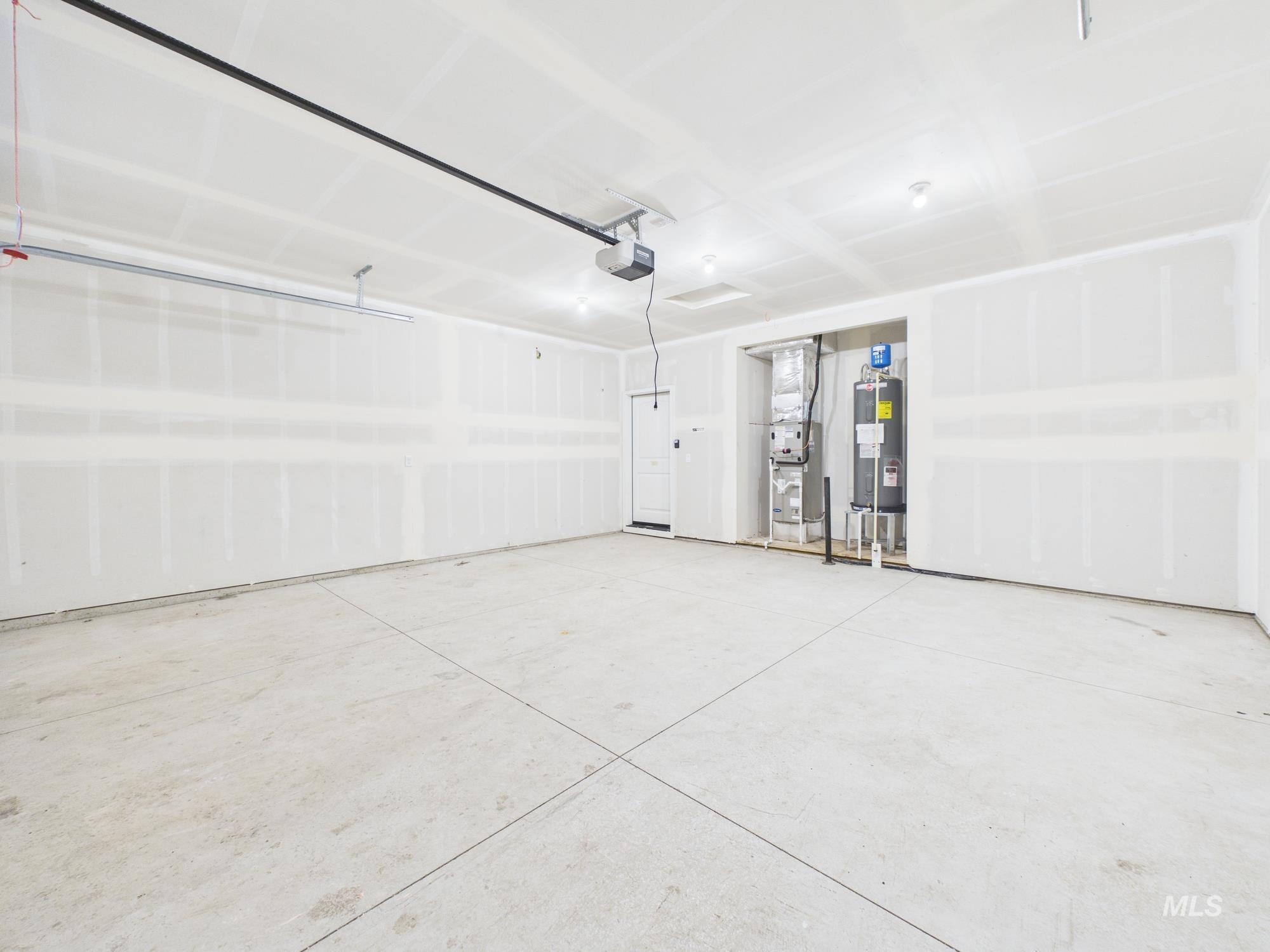 1545 Trail Way Weiser, ID 83672 - Photo 32 of 50 Garage featuring heating unit, water heater, and a garage door opener