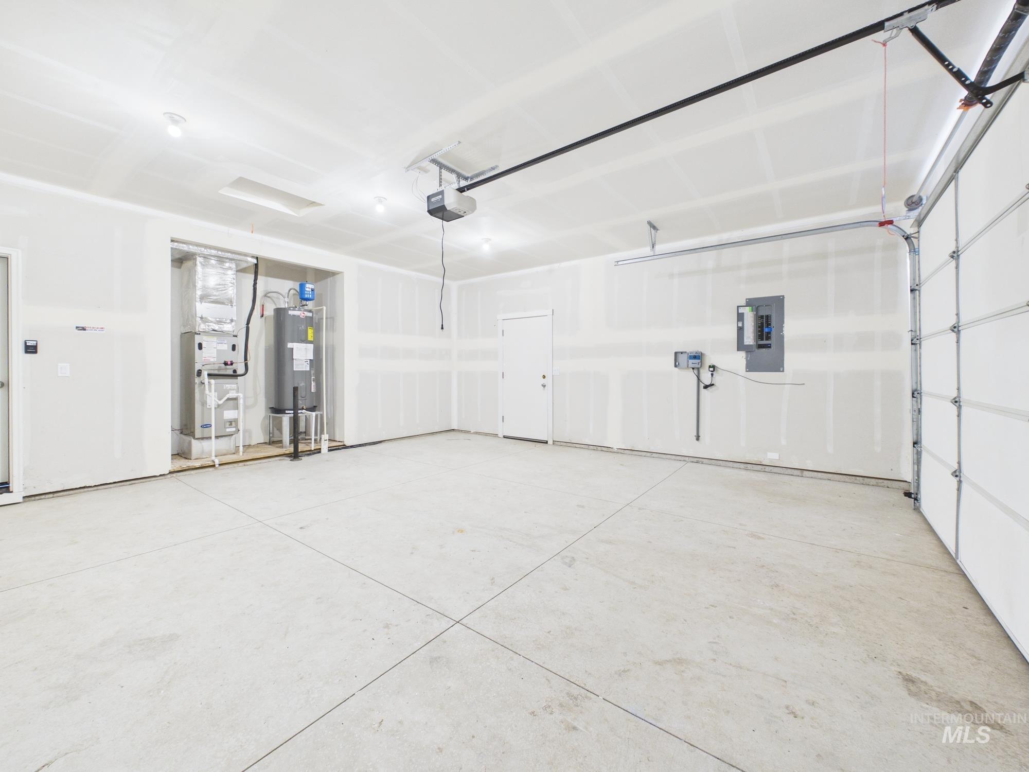 1545 Trail Way Weiser, ID 83672 - Photo 33 of 50 Garage featuring electric panel, heating unit, water heater, and a garage door opener