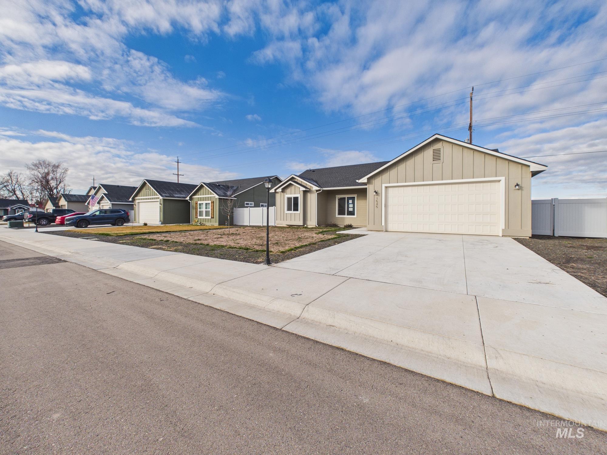 1545 Trail Way Weiser, ID 83672 - Photo 47 of 50 Single story home with board and batten siding, a garage, concrete driveway, and a residential view