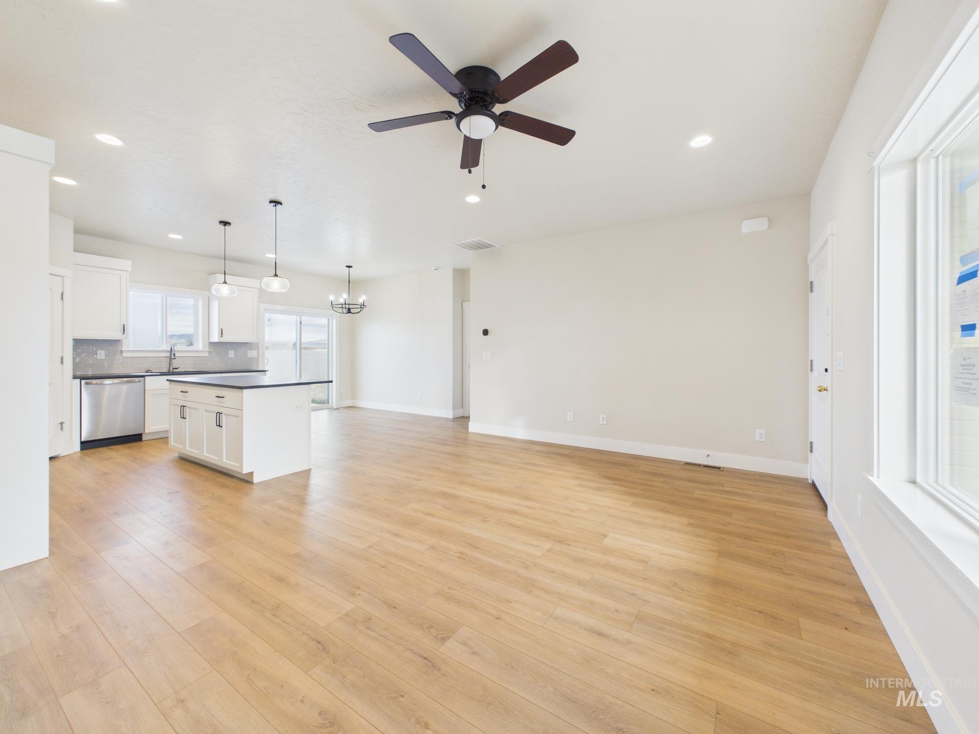 1545 Trail Way Weiser, ID 83672 - Photo 6 of 50 Unfurnished living room featuring ceiling fan, light wood-style flooring, and hanging lights
