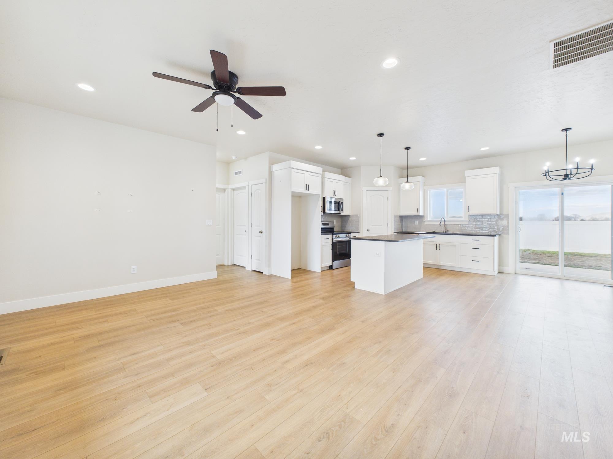 1545 Trail Way Weiser, ID 83672 - Photo 7 of 50 Unfurnished living room with ceiling fan, light wood-style floors, and hanging lights