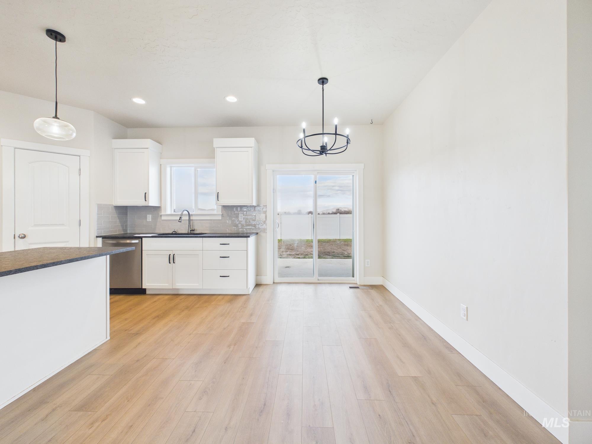 1545 Trail Way Weiser, ID 83672 - Photo 8 of 50 Kitchen with white cabinetry, suspended lighting, and light wood-style flooring