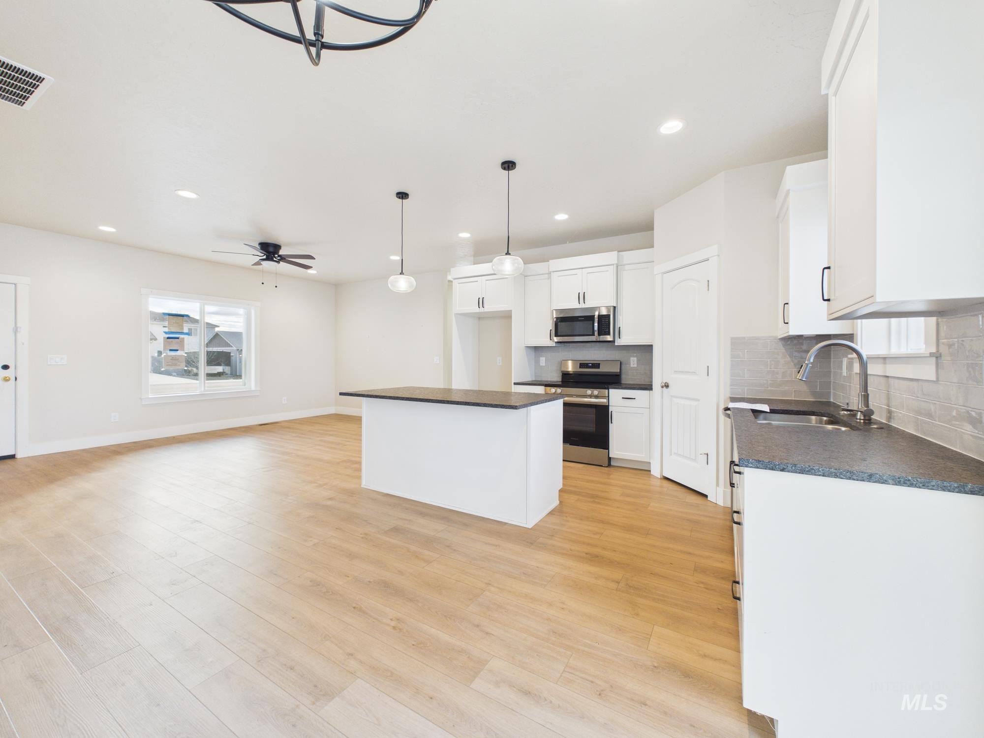 1545 Trail Way Weiser, ID 83672 - Photo 50 of 50 Kitchen featuring a kitchen island, stainless steel appliances, pendant lighting, tasteful backsplash, and open floor plan