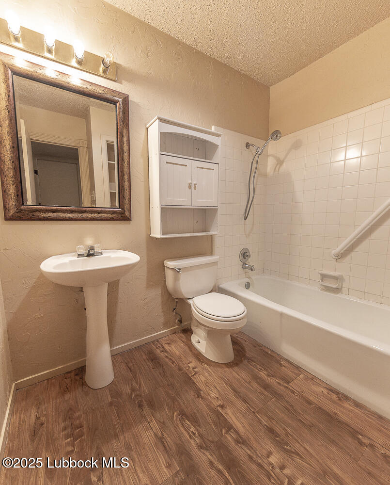 5750 38th Street Lubbock, TX 79407 - Photo 12 of 24 a bathroom with a toilet sink and mirror