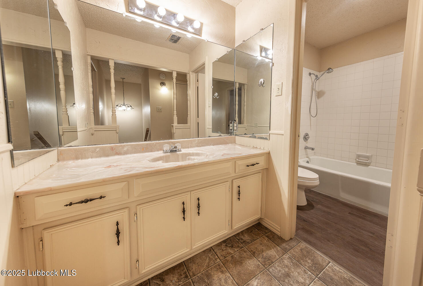 5750 38th Street Lubbock, TX 79407 - Photo 17 of 24 a bathroom with a double vanity sink a mirror and a bathtub
