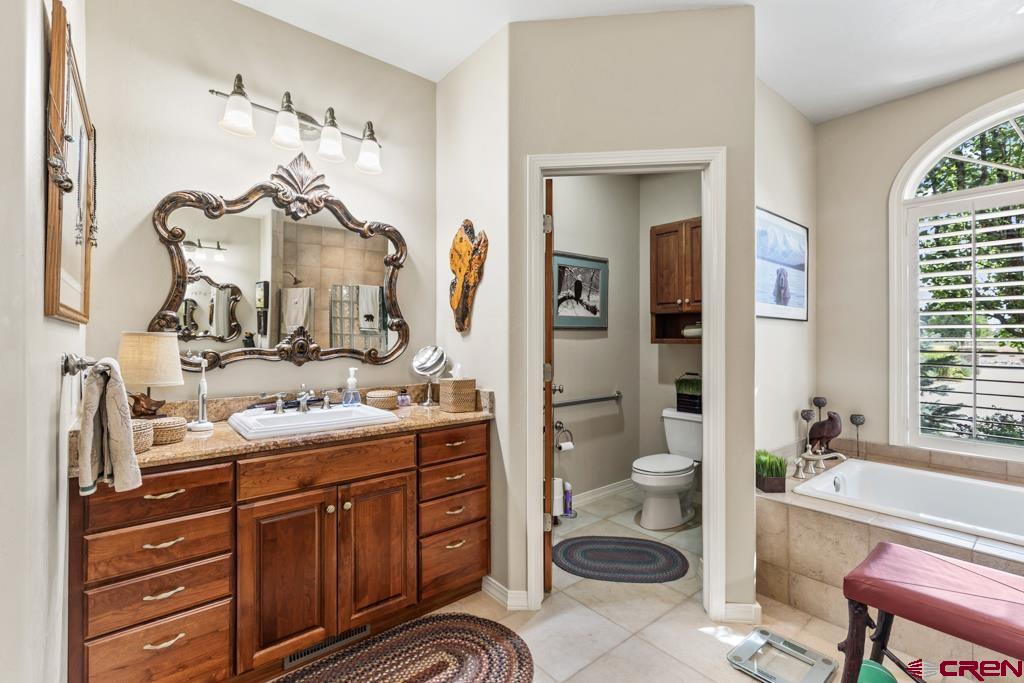 15103 6260th Road Montrose, CO 81403 - Photo 25 of 45 a bathroom with a double vanity sink a toilet and a mirror