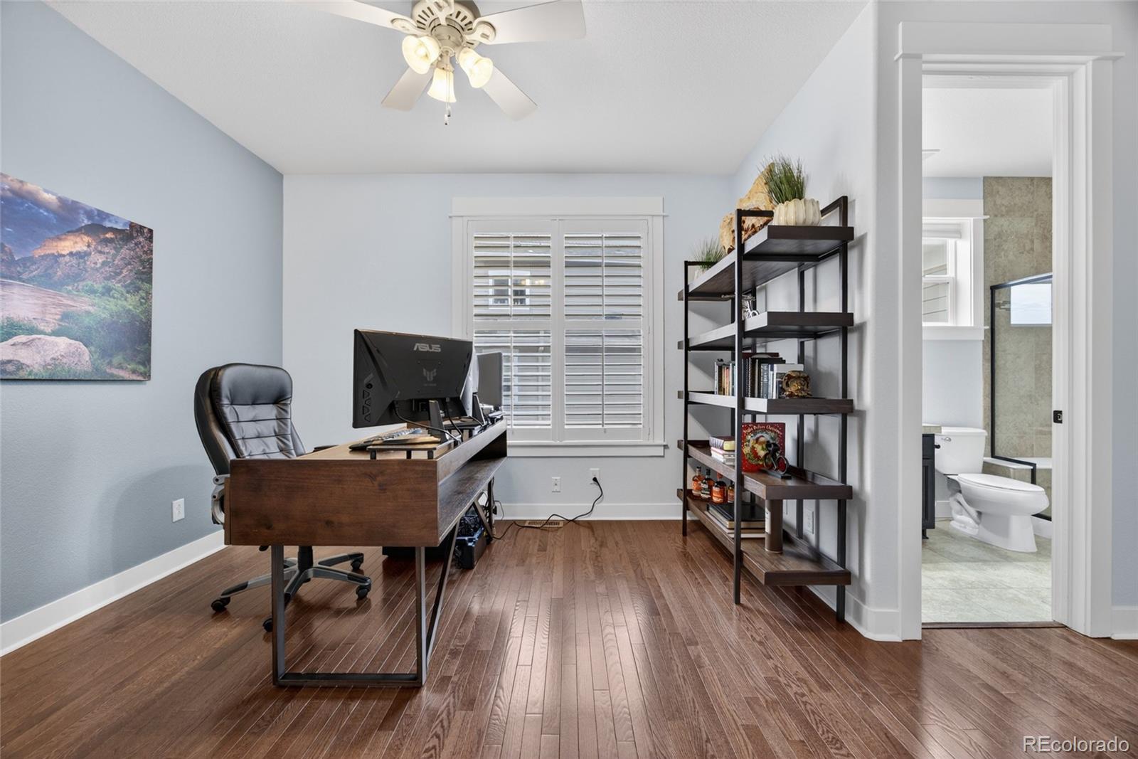 20554 East Shady Ridge Road Parker, CO 80134 - Photo 20 of 49 a workspace with wooden floor and a bookshelf