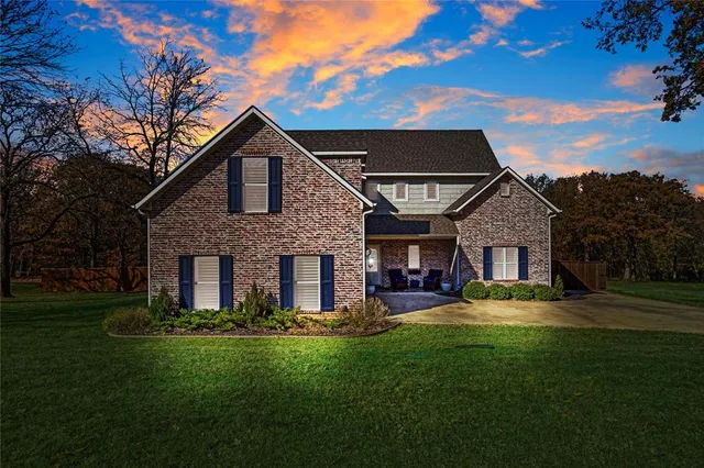 a view of a yard in front of a house with a large tree