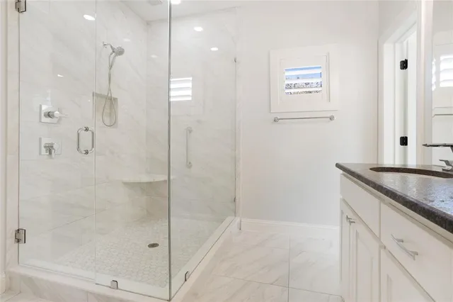 a bathroom with a granite countertop sink a shower and a mirror