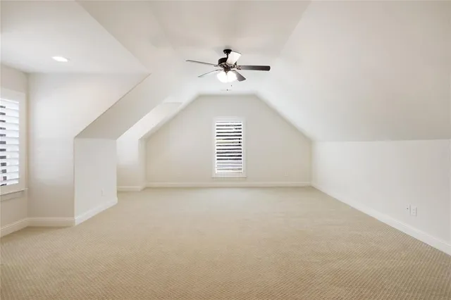 an empty room with windows and ceiling fan