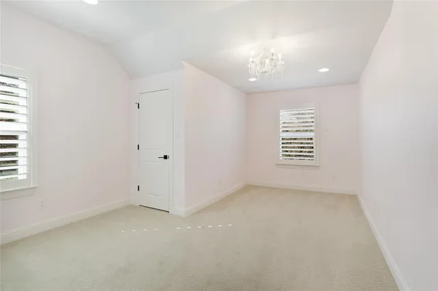 en empty room with windows and chandelier fan