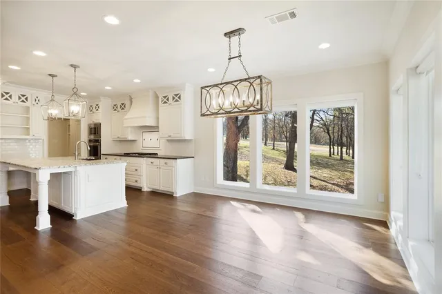 a view of kitchen with stainless steel appliances granite countertop cabinets and wooden floor