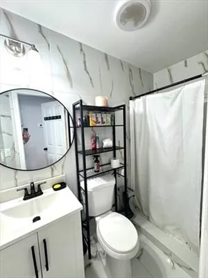 a bathroom with a toilet sink and shower