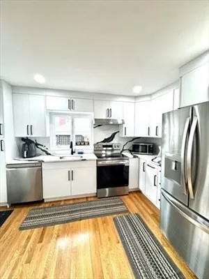 a kitchen with a sink stainless steel appliances and white cabinets