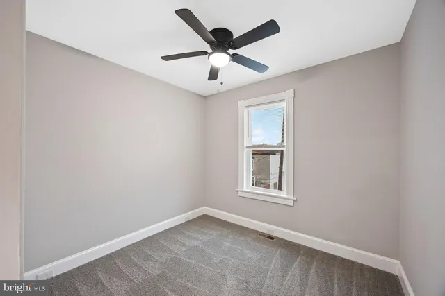 an empty room with window and ceiling fan