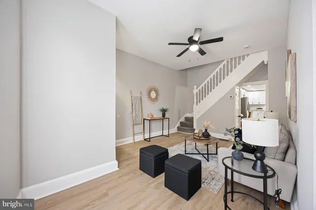 a living room with couches chairs and closet with wooden floor