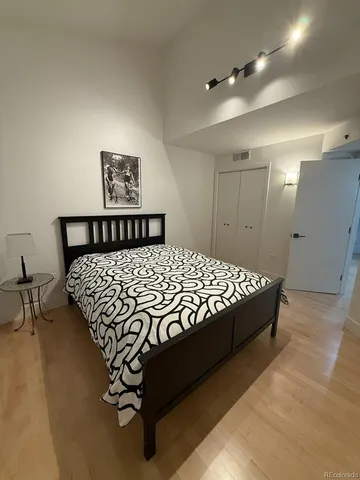 a bedroom with a bed and painting on the wall