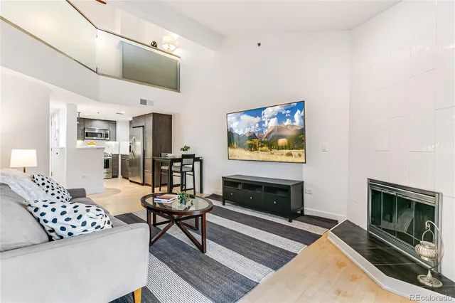 a living room with furniture a flat screen tv and a fireplace