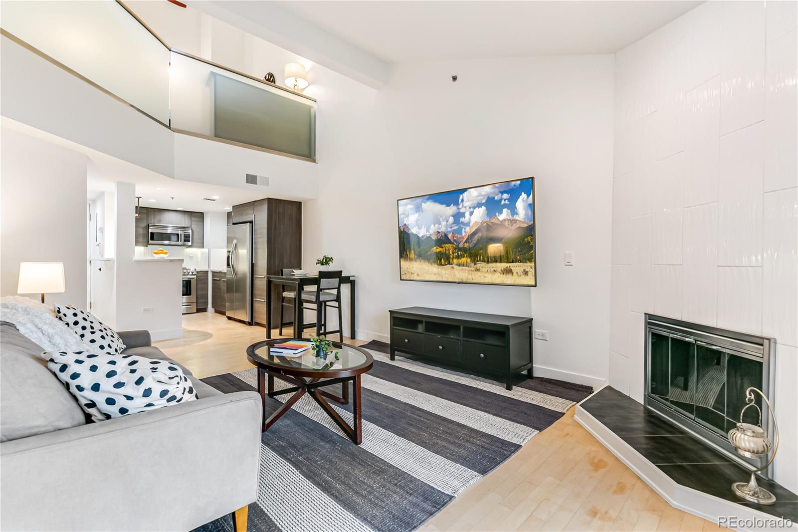 350 Detroit Street, Unit 413 Denver, CO 80206 - Photo 2 of 25 a living room with furniture a flat screen tv and a fireplace