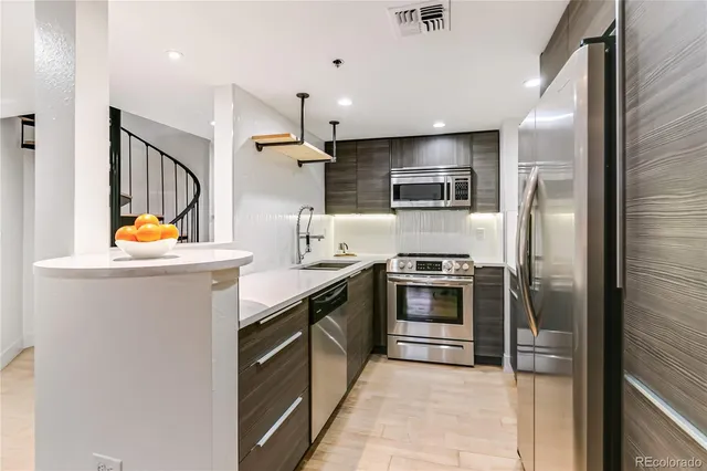 a kitchen with stainless steel appliances granite countertop a refrigerator and a sink