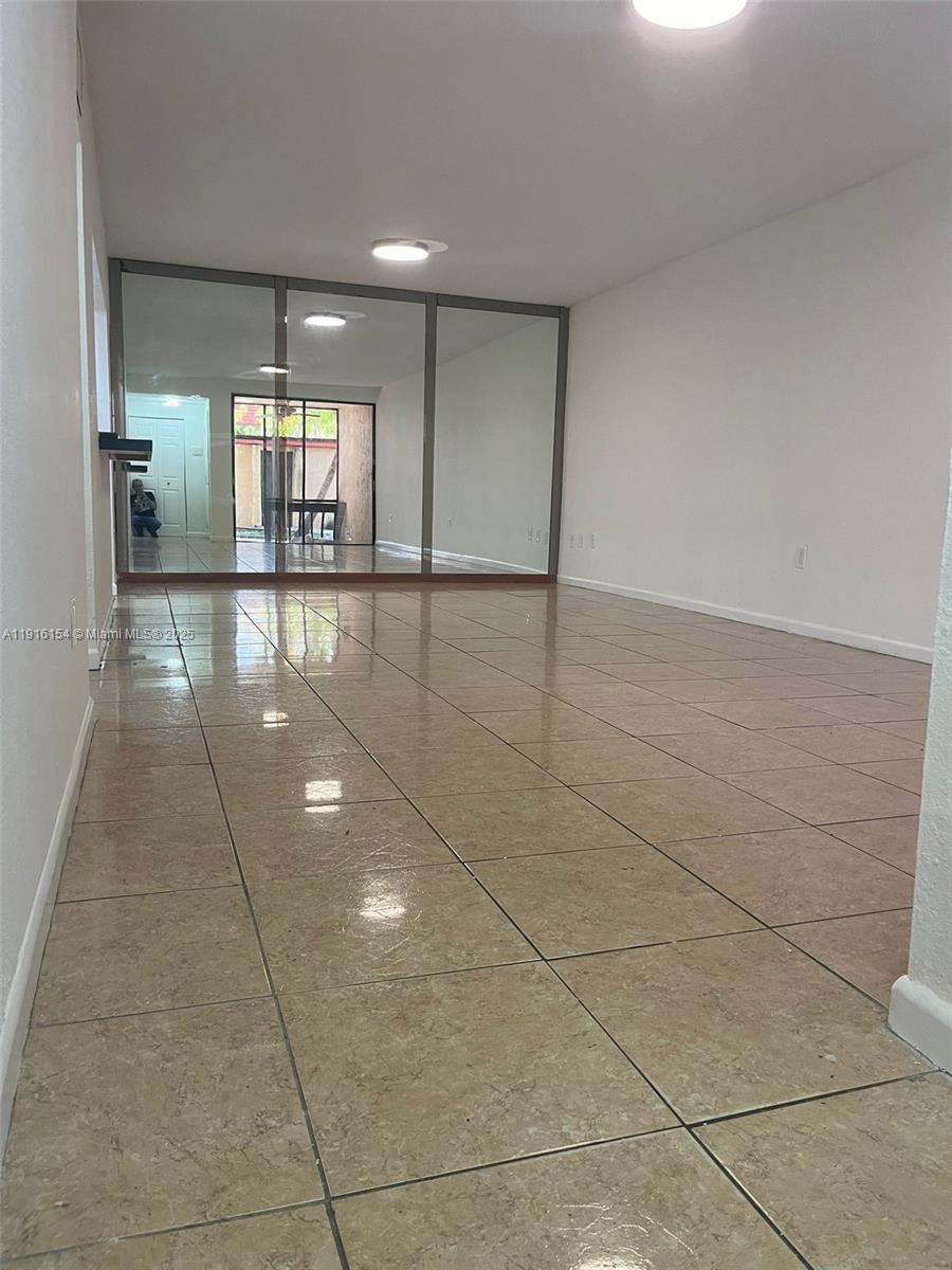 800 Northeast 199th Street, Unit 106D Miami, FL 33179 - Photo 3 of 20 a view of a hallway with an empty room and chandelier fan