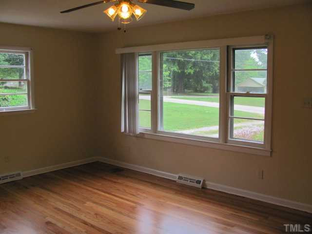 222 Forestville Road Wake Forest, NC 27587 - Photo 2 of 18 a view of an empty room with wooden floor and a window