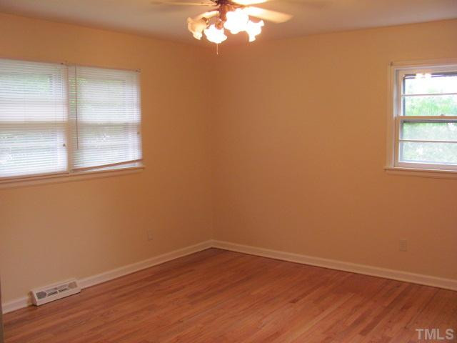 222 Forestville Road Wake Forest, NC 27587 - Photo 9 of 18 a view of an empty room with wooden floor and a window