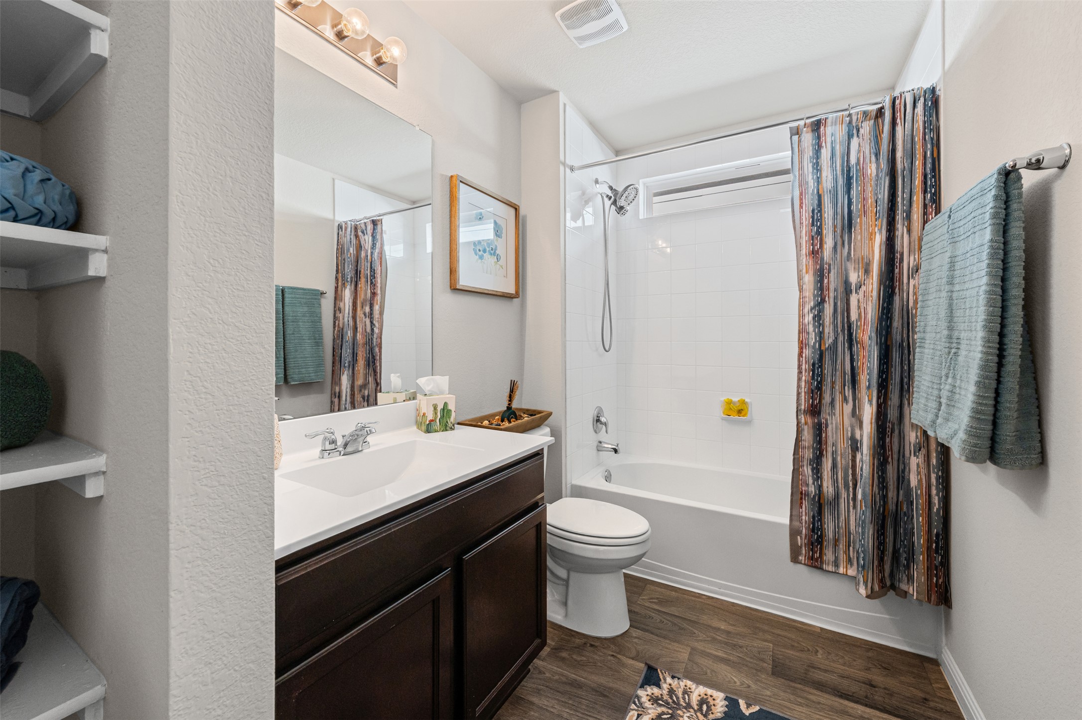 132 Dunlin Lane Leander, TX 78641 - Photo 21 of 34 Full bath featuring shower / bathtub combination with curtain, vanity, and dark wood-style flooring