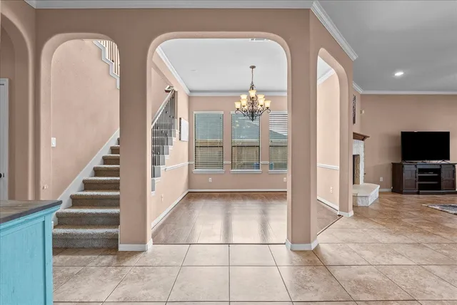 a large white kitchen with a large window and kitchen island
