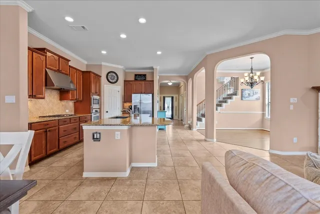 a living room with furniture a flat screen tv and a open kitchen view