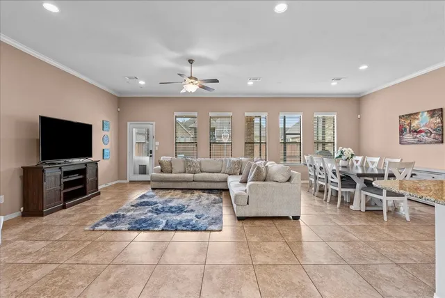a living room with furniture and a flat screen tv with kitchen view