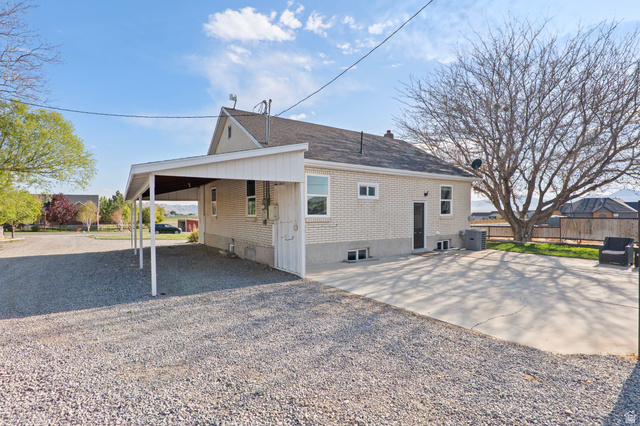 115 East 1600th Street North Santaquin, UT 84655 - Photo 30 of 52 Light brick exterior featuring a multi-car carport and a concrete patio