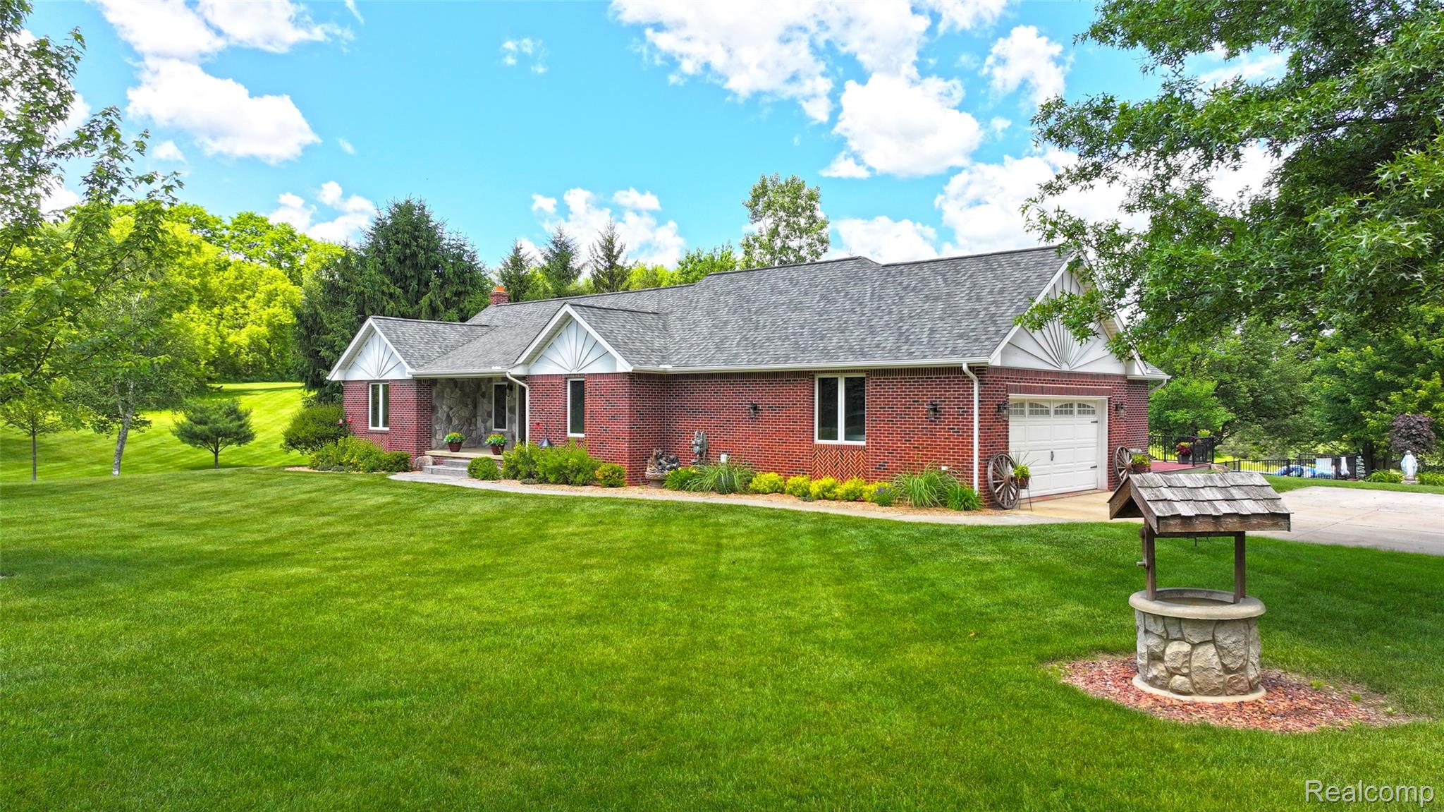 5233 Crawford Road Dryden, MI 48428 - Photo 62 of 95 Brick exterior residence with a gray shingled roof, white garage door, and a stone-faced decorative well