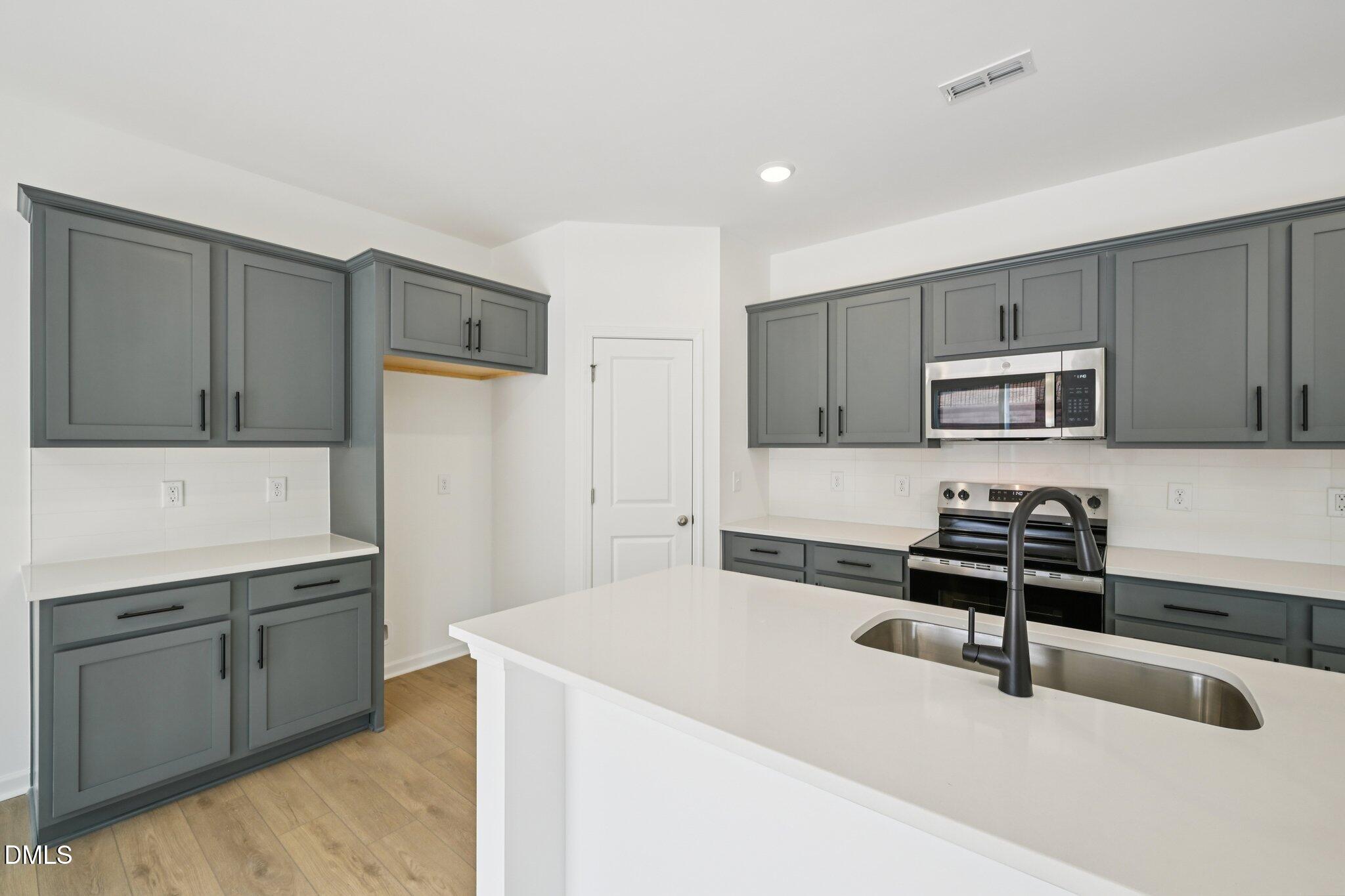 11793 Salers Loop Middlesex, NC 27557 - Photo 12 of 53 a kitchen with a sink a stove and cabinets