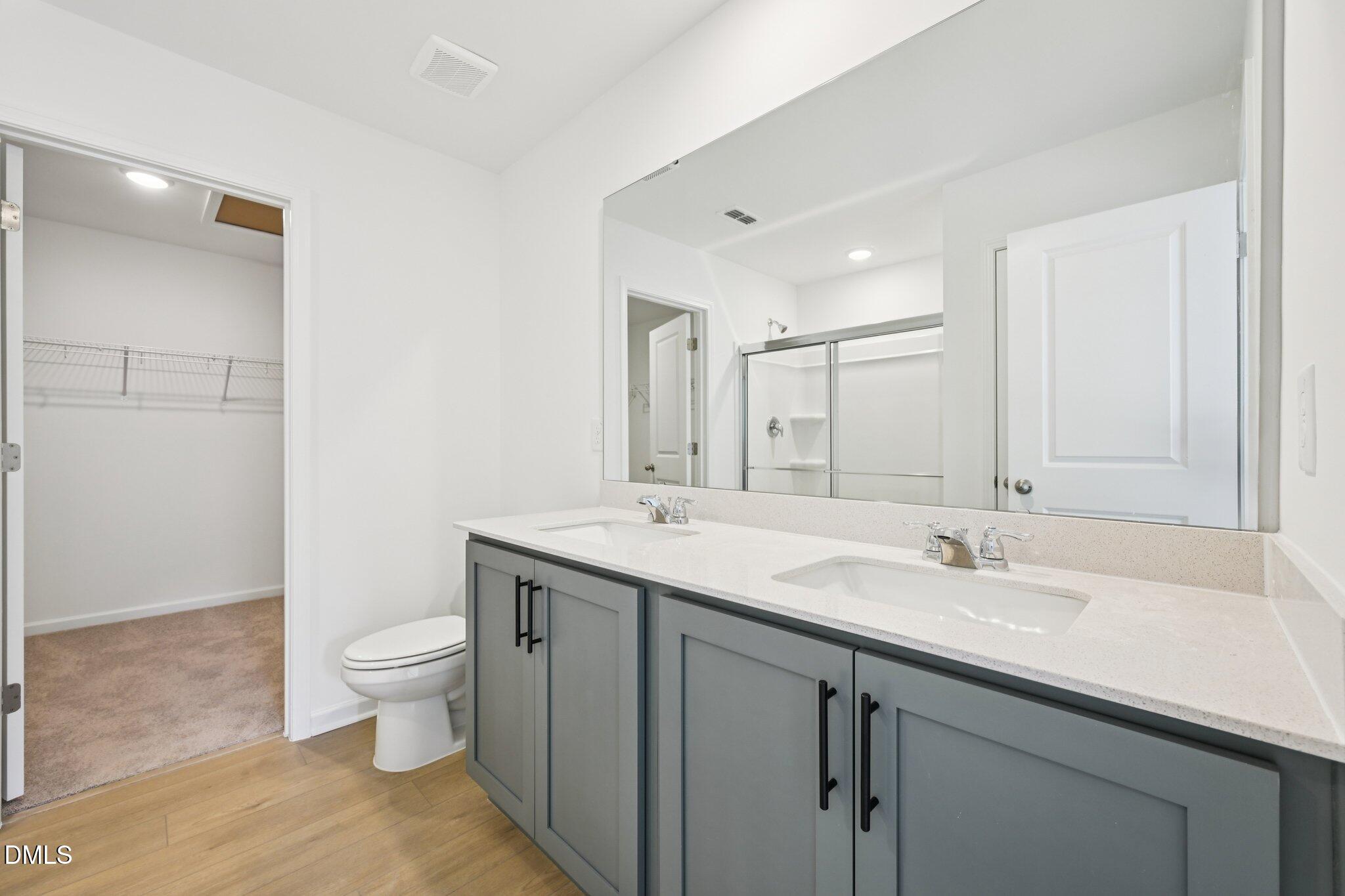 11793 Salers Loop Middlesex, NC 27557 - Photo 27 of 53 a bathroom with a double vanity sink a toilet and a mirror